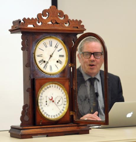 Antiques appraiser Mark Moran examining a clock.